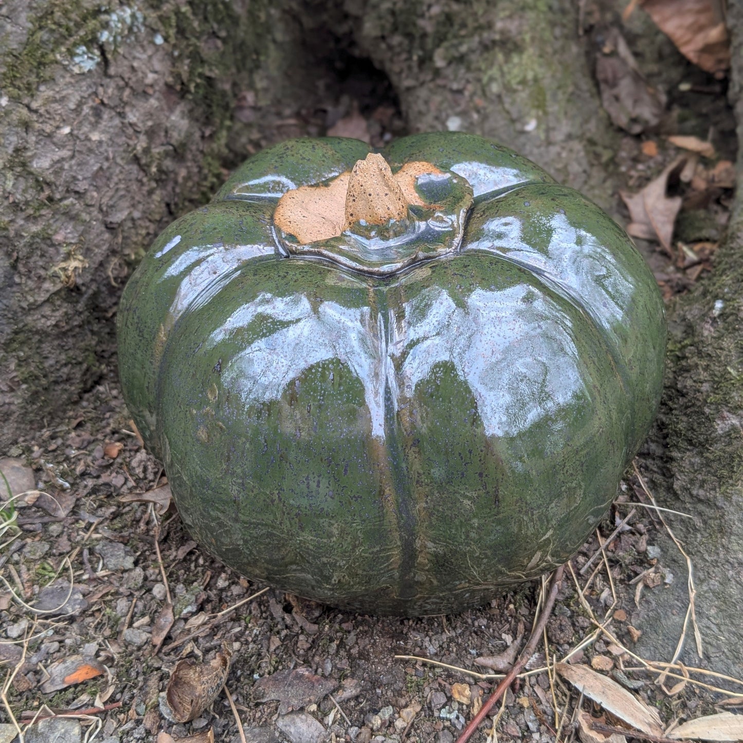 Small ceramic pumpkin on dry leaves