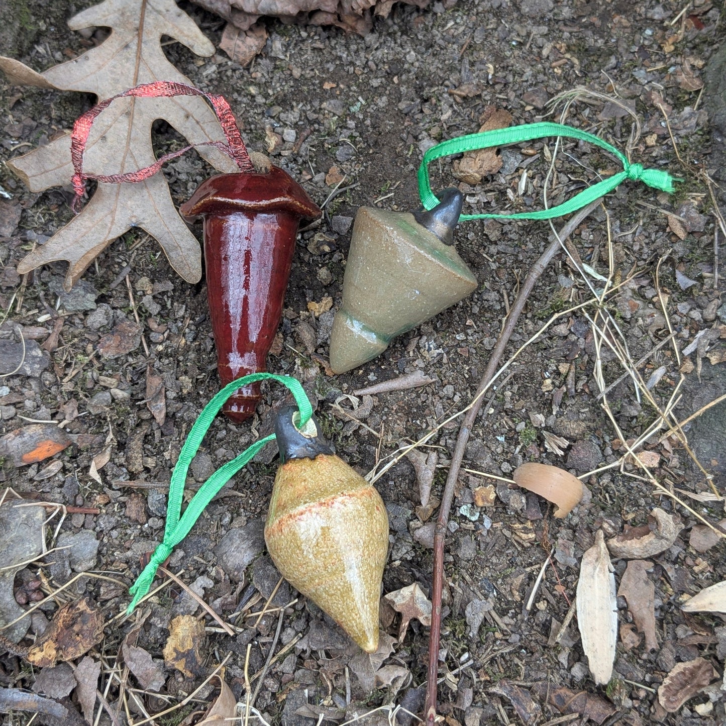 Colorful ceramic ornaments on a natural stone surface with leaves and twigs.